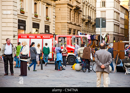 Un incendio del motore ai Vigili del Fuoco entra nella Piazza della Repubbica nel centro di Firenze, Italia. I turisti e la gente del posto si mescolano. Foto Stock