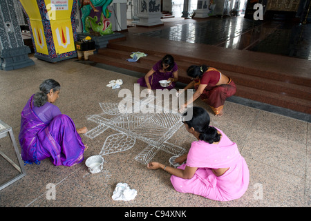 Little India: Sri Srinivasa Perumal Temple - donne verniciatura del pavimento Foto Stock