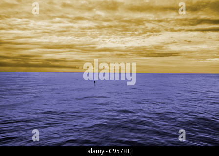 Nuvoloso blue sky lasciando per orizzonte al di sopra di una superficie blu del mare Foto Stock