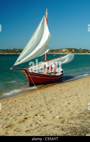 Vecchio latino classico barca vela in atterraggio a Porto Pollo beach, Palau Sardegna Foto Stock