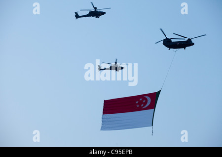 Singapore elicotteri militari e la bandiera di Singapore Foto Stock