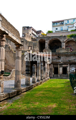 Le case moderne di Ercolano guardare in giù su colonne corinzie scanalate di supporto del portico del Palaestra, Ercolano Foto Stock