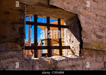 Immagine guardando attraverso il arrugginita le sbarre di una prigione oldtime finestra al patibolo e una hangmans cappio. Foto Stock