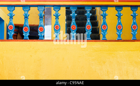 Colorato di giallo e blu sulla balaustra di una casa indiana. Andhra Pradesh, India Foto Stock