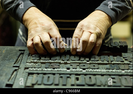 Mani lavorando con blocco di stampa lettere Foto Stock