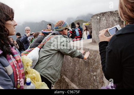 Intihuatana altare di pietra in corrispondenza di antiche rovine Inca di Machu Picchu, il più noto sito turistico nelle montagne delle Ande, Perù. Foto Stock