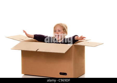 Bambino in una scatola di cartone. Si trova nella scatola quando si muove. Foto Stock