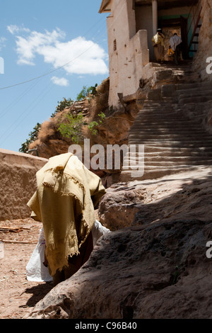 Cristiano ortodosso di sacerdoti si arrampica fino alla scogliera-top monastero Debre Damo sul confine eritreo in Etiopia settentrionale, Africa Foto Stock