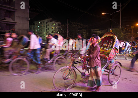 Rickshaws guidando le persone a notte a Dhaka. Foto Stock