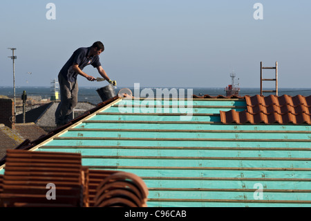 Builder copritetti lavorando sul tetto Foto Stock