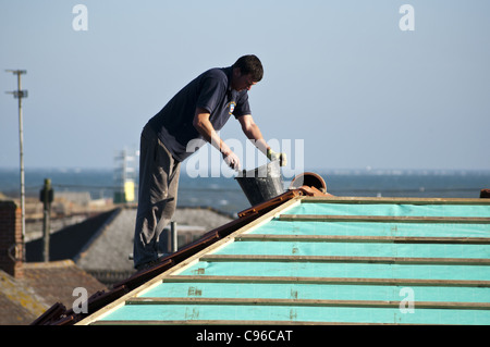 Builder copritetti lavorando sul tetto Foto Stock