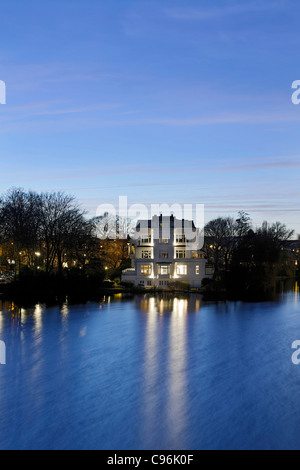 Villa al Krugkoppel al crepuscolo, Ponte Krugkoppelbruecke, Esterno lago Alster, Alster Amburgo, Germania, Europa Foto Stock