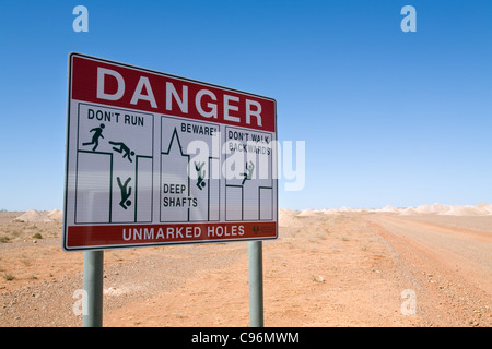 Segnaletica di pericolo attenzione della miniera a cielo aperto alberi nell'opale di Coober Pedy, South Australia, Australia Foto Stock