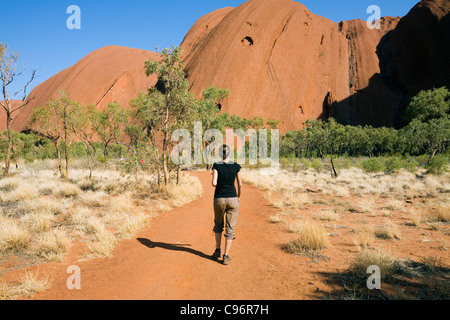 Escursionista su Uluru (Ayers Rock) di base a piedi. Uluru-Kata Tjuta National Park, il Territorio del Nord, l'Australia Foto Stock