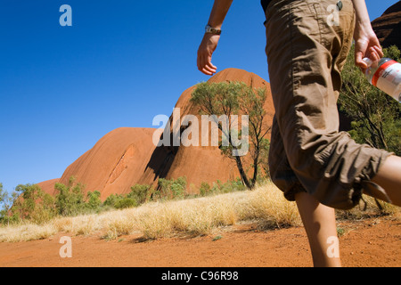 Escursionista su Uluru (Ayers Rock) di base a piedi. Uluru-Kata Tjuta National Park, il Territorio del Nord, l'Australia Foto Stock