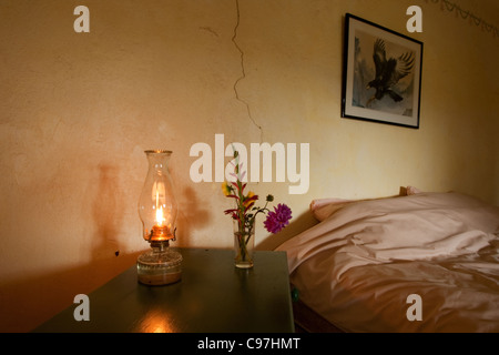 Camera da letto con interni in vecchio stile lampada di paraffina e piccoli fiori Foto Stock