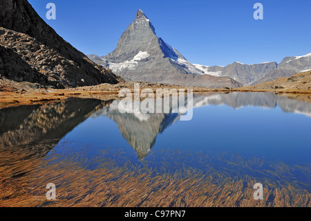 Il Cervino è riflessa nel lago Riffelsee al di sopra di Zermatt. Gornegrat ferrovia di montagna offre un facile accesso a questo punto di vista Foto Stock