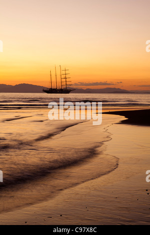 La spiaggia e la vela cruiseship Star Flyer (Star Clippers crociere) al tramonto Puerto Caldera Puntarenas Costa Rica America Centrale un Foto Stock