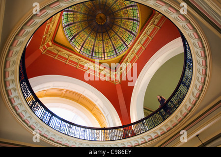 Una donna guarda fino a la coloratissima cupola in vetro colorato del Queen Victoria Building. Sydney, Nuovo Galles del Sud, Australia Foto Stock