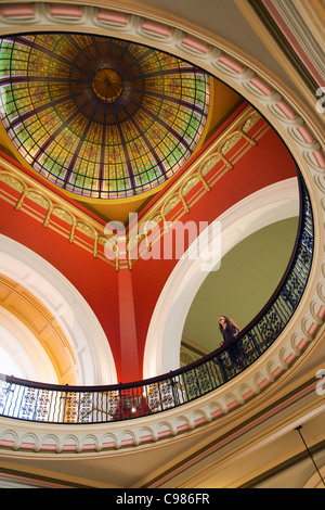 Una donna guarda fino a la coloratissima cupola in vetro colorato del Queen Victoria Building. Sydney, Nuovo Galles del Sud, Australia Foto Stock