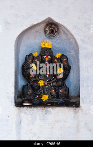 Signore Ganesha statua in un incavo arcuato in una parete. Andhra Pradesh, India Foto Stock