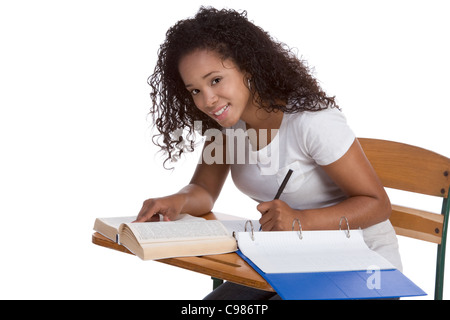 Serie di istruzione - etnica nero donna di alta scuola studente seduto da banco di scuola facendo i compiti di scuola Foto Stock