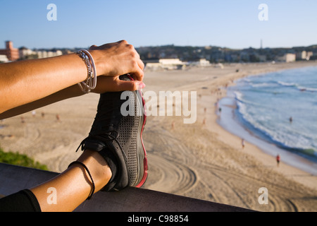 Donna di eseguire tratti affacciato sulla spiaggia Bondi. Sydney, Nuovo Galles del Sud, Australia Foto Stock