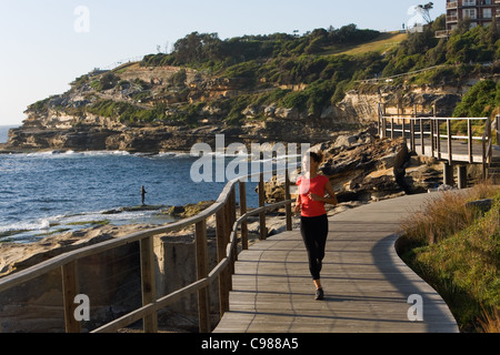 Donna jogging lungo il Bondi a Coogee sentiero costiero. Sydney, Nuovo Galles del Sud, Australia Foto Stock