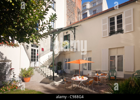 Un ristorante e bar Colazione La colazione è servita al di fuori in un hotel turistico cortile (Francia). Petit-déjeuner servi en extérieur dans une cour d'hôtel. Foto Stock