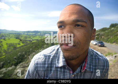Giovane americano africano uomo che guarda fuori nella distanza Foto Stock