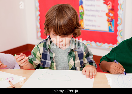 Ragazzo il disegno di una foto in classe Foto Stock