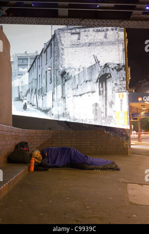 Persona senzatetto in sacco a pelo in Street, Sydney, Australia Foto Stock