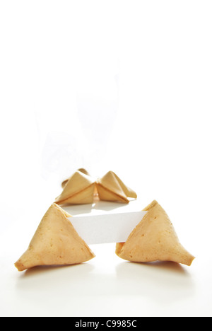 Asian Fortune cookie con carta bianca isolata su sfondo bianco. Foto Stock