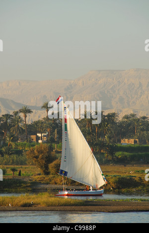 LUXOR, Egitto. Una solitaria Traversata in Felucca giù il Nilo al tramonto, con la fertile a ovest del fiume dietro. 2009. Foto Stock