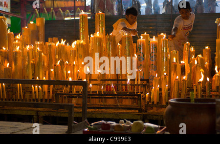 Gli operatori in bianco mantenere acceso candele durante il Festival vegetariano al San Jao Sien Khong santuario cinese a Bangkok. Foto Stock