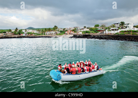 Dinghy prende gruppo turistico torna alla nave da crociera Puerto Baquerizo Moreno town, San Christobal isola, Galapagos, Ecuador. Foto Stock