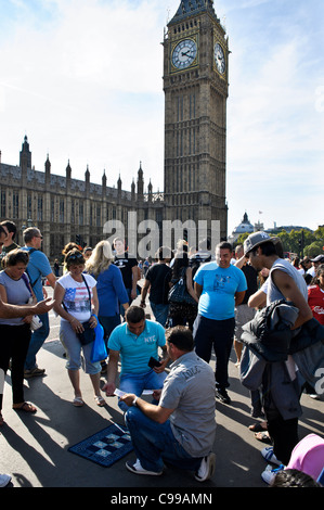 La folla gamble indovinare quale cup la palla è sotto all'ombra del Big Ben sul Westminster Bridge, Londra. Foto Stock