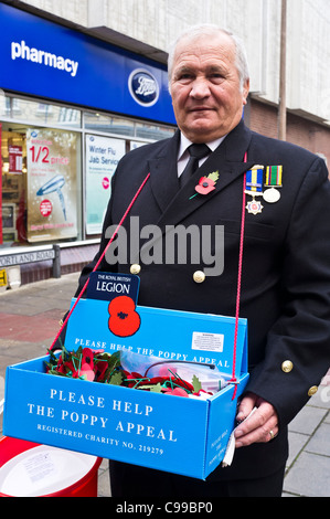 Un veterano decorato raccoglie per la annuale del Regno Unito appello di papavero gestito dalla Royal British Legion in aiuto di ex-combattenti. Foto Stock