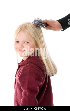 Spazzola per capelli spazzola per capelli ragazza avente la sua lunga spazzolato bionda intricato groviglio tirato male danneggiando il bambino ragazza madre toddler spazzolatura gr Foto Stock