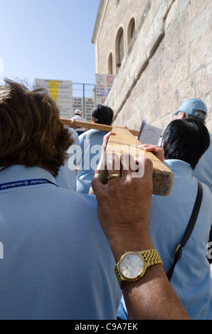 Gruppo di pellegrini che porta una croce di legno lungo la via della croce. Gerusalemme la città vecchia Foto Stock