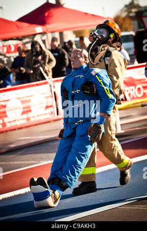 Un vigile del fuoco trascina un 175-pound manichino indietro indossando estinzione completa ingranaggio e lavorano contro l'orologio durante le finali internazionali del pompiere combattimento Challenge il 18 novembre 2011 in Myrtle Beach, Carolina del Sud. Foto Stock