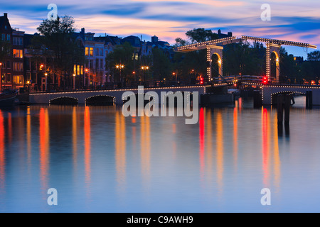 Ora blu di Amsterdam con la vista del Magere Brug (Skinny Bridge) dopo il tramonto. Foto Stock
