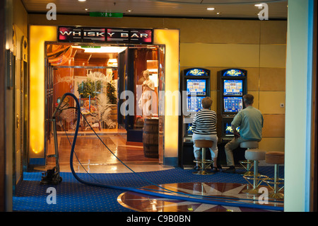 Un paio di giocare le slot machines accanto a un aspirapolvere sulla nave da crociera birka paradise casino Foto Stock