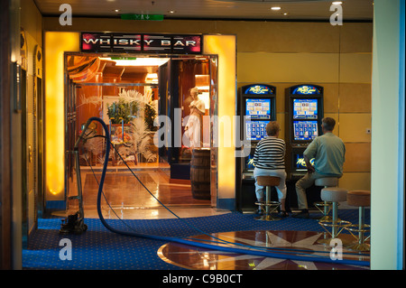 Un paio di giocare le slot machines accanto a un aspirapolvere sulla nave da crociera birka paradise casino Foto Stock