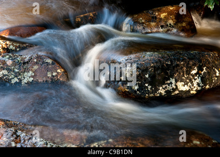 Immagine ravvicinata di un fiume che scorre intorno a massi e rocce Foto Stock