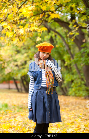 Ragazza vivace in arancione beret nella foresta di autunno Foto Stock