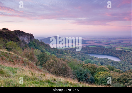 Bellissima Scenic lunga distanza vista sul lago Gormire, cappa Hill, Whitestone Cliff & campagna sunrise - Sutton Bank, North Yorkshire, Inghilterra, Regno Unito. Foto Stock