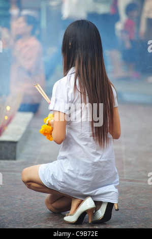 Donna orante presso il Santuario di Erawan a Bangkok, in Thailandia Foto Stock