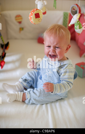 11 mese baby boy che grida nel lettino, London, England, Regno Unito Foto Stock