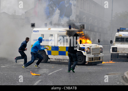 Nazionalista mascherato giovani gettare bombe molotov a PSNI veicoli durante i tumulti in Bogide, Londonderry. Foto Stock